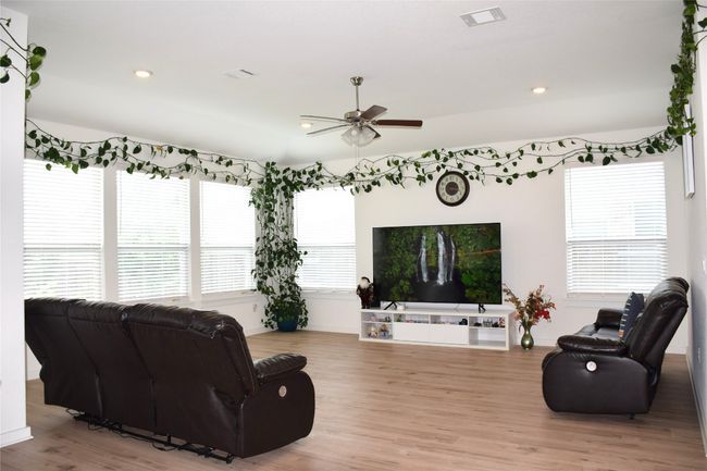 Living area with ceiling fan, light wood finished floors, recessed lighting, and baseboards | Image 5