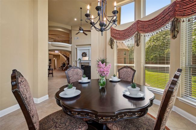 Tiled dining area with arched walkways, a chandelier, healthy amount of natural light, and a high ceiling | Image 14