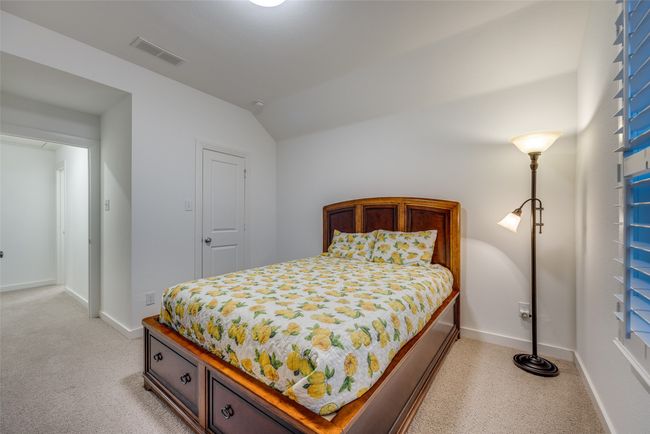 Bedroom featuring light carpet, visible vents, baseboards, and vaulted ceiling | Image 31