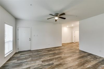 Empty room with dark hardwood / wood-style floors, ceiling fan, and plenty of natural light | Image 3