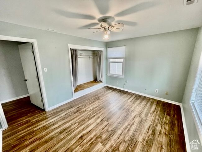 Unfurnished bedroom with a closet, baseboards, a ceiling fan, and wood finished floors | Image 8