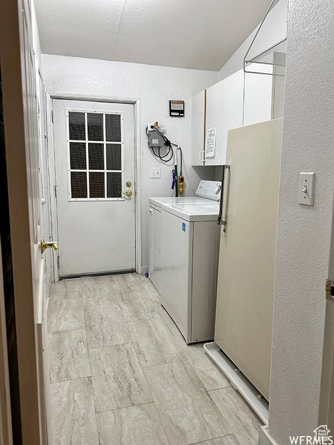 Laundry area featuring laundry area and a textured wall | Image 50