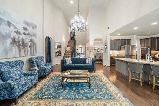 This inviting open-concept living space area open to the modern kitchen with a large island, and a dining space that seamlessly connects to the rest of the home. | Image 5