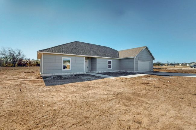 Ranch-style house featuring concrete driveway, an attached garage, and roof with shingles | Image 5
