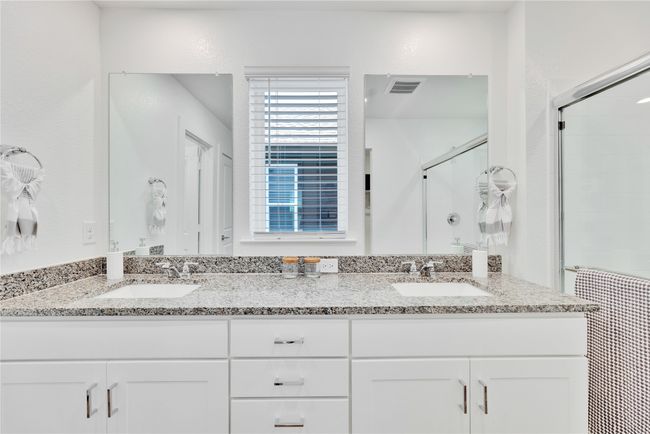 Bathroom featuring double vanity, a stall shower, a sink, and visible vents | Image 18