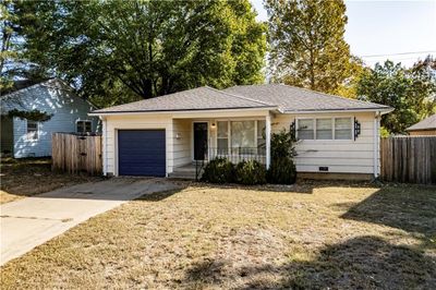 Ranch-style house featuring a front yard and a garage | Image 1