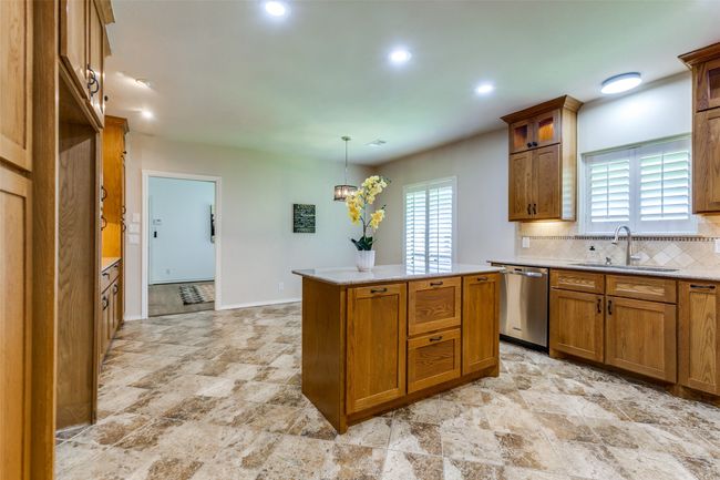 View back from the kitchen into the breakfast room and through to the den. | Image 10