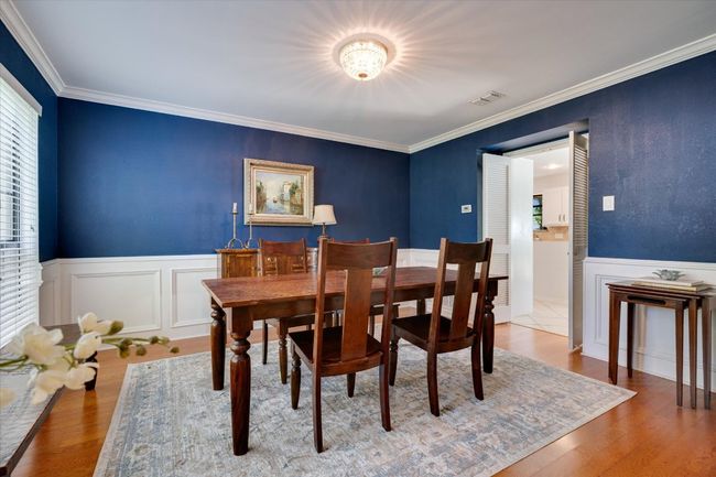 Dining space with wainscoting, crown molding, wood finished floors, and a decorative wall | Image 8