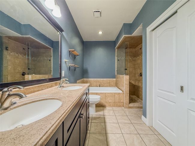 Bathroom with a bath, a shower stall, tile patterned floors, double vanity, and recessed lighting | Image 24