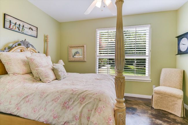 Bedroom with multiple windows, baseboards, finished concrete flooring, and a ceiling fan | Image 18