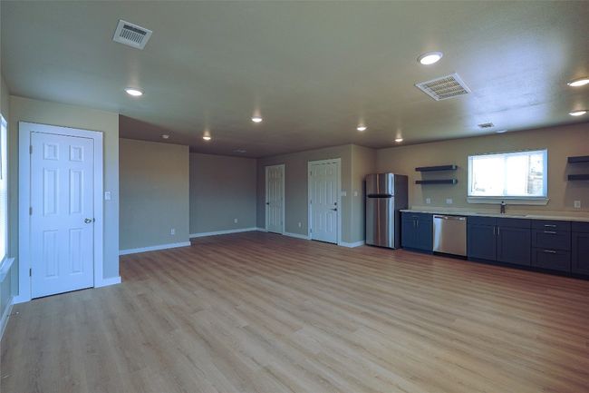 Kitchen with appliances with stainless steel finishes, light countertops, light wood-style floors, recessed lighting, and open shelves | Image 15