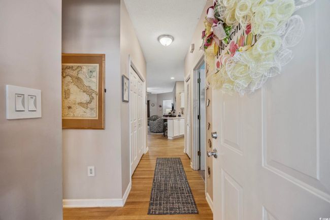 Corridor with light wood-type flooring and baseboards | Image 6
