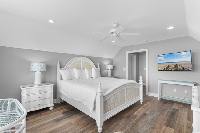 Oceanfront Primary Bedroom featuring vaulted ceiling, wood finished floors, recessed lighting, a ceiling fan | Image 26