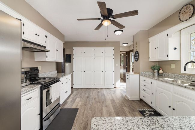 Beautifully updated kitchen with brand-new granite countertops, sleek LVP flooring, and stainless steel appliances! | Image 7