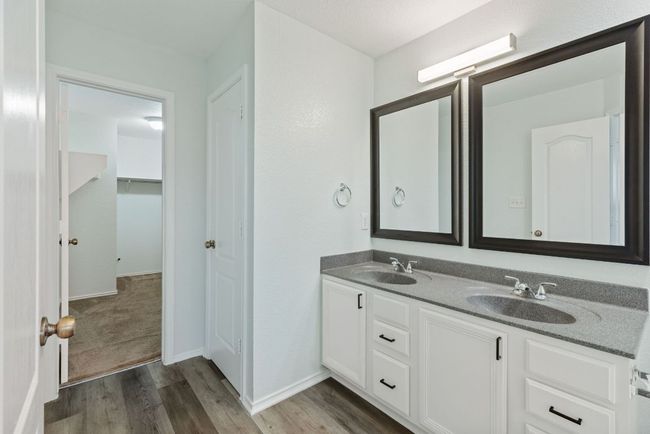 Full bathroom with Grey wood-style vinyl floors, double vanity, and baseboards | Image 26