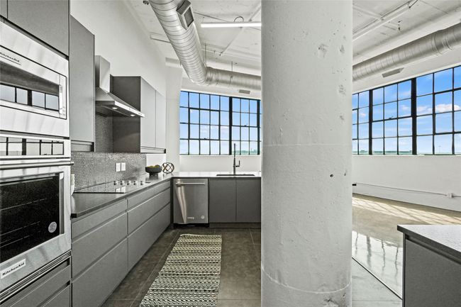 Kitchen with a sink, gray cabinets, appliances with stainless steel finishes, and a healthy amount of sunlight | Image 16