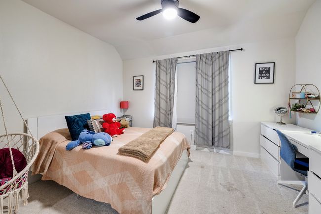 Carpeted bedroom with an office area, lofted ceiling, and ceiling fan | Image 33