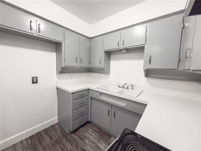 Kitchen with gray cabinetry, sink, and dark wood-type flooring | Image 6