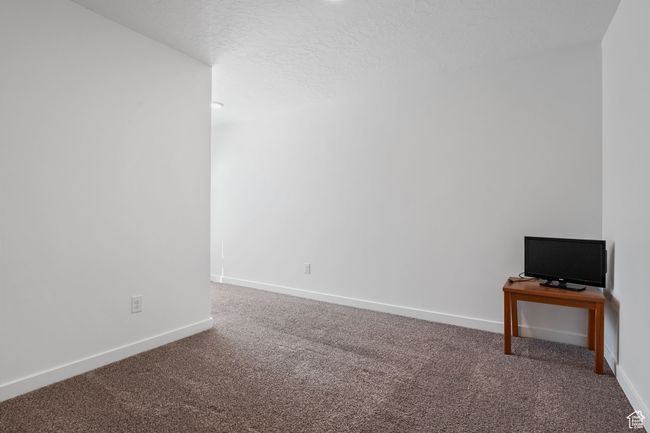 Empty bedroom featuring baseboards, carpet, and a textured ceiling | Image 14