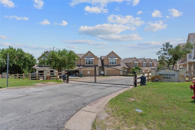 View of street with a gate, a gated entry, curbs, and a residential view | Image 7