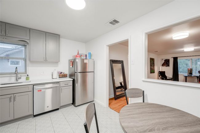 Kitchen featuring stainless steel appliances, gray cabinets, a sink, and light countertops | Image 32