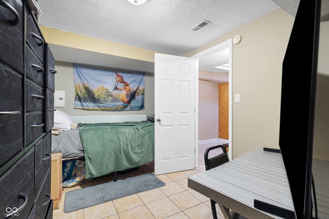 interior space featuring a textured ceiling, visible vents, and light tile patterned floors | Image 26