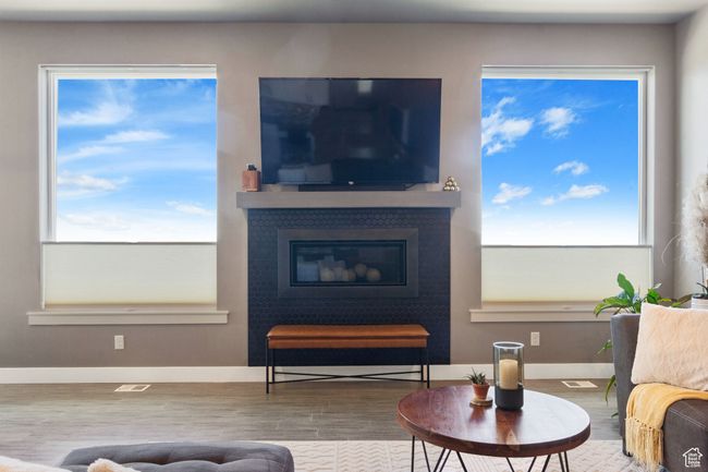 Living room featuring baseboards, wood finished floors, and a glass covered fireplace | Image 11