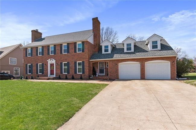 Colonial inspired home with a garage, a front lawn, concrete driveway, and brick siding | Image 64