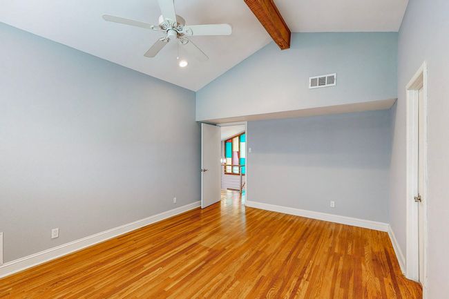 Bedroom on second floor with ceiling fan, beam ceiling, and wood floors | Image 13