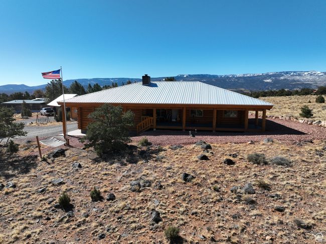 Back of property featuring log exterior, a mountain view, and metal roof | Image 29