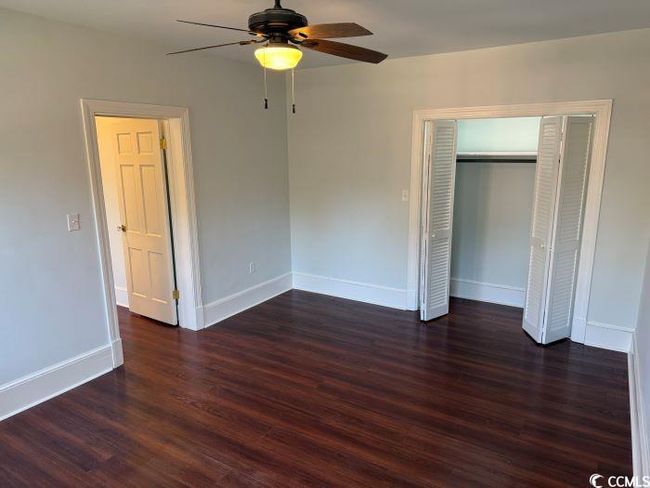 Unfurnished bedroom with ceiling fan, a closet, and dark hardwood / wood-style flooring | Image 19