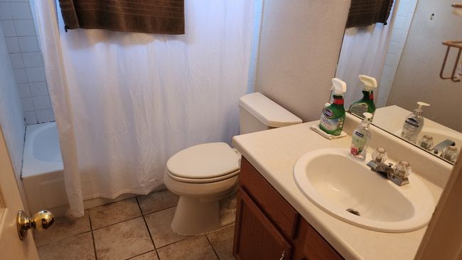 Bathroom featuring tile patterned flooring, vanity, and shower / tub combo | Image 13