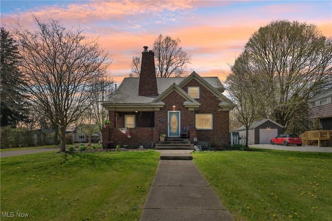 Bungalow featuring a chimney, an outbuilding, brick siding, a front yard, and a garage | Image 44