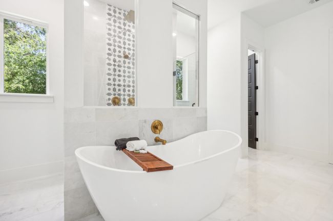 Bathroom with marble tiled flooring, a freestanding bath, and tile walls | Image 19