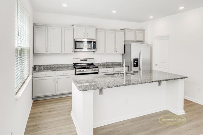 Kitchen featuring stainless steel appliances, a sink, healthy amount of natural light, a center island with sink, and recessed lighting | Image 9