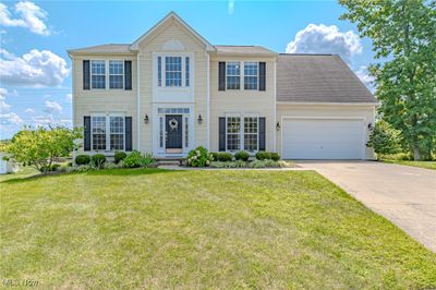 Colonial home with a garage and a front yard | Image 1