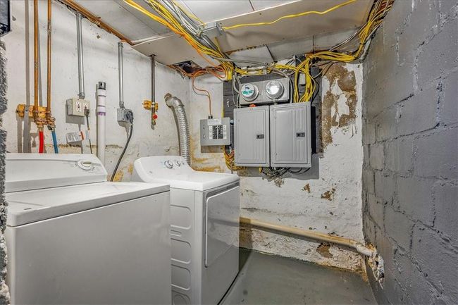 Laundry room featuring electric panel and Unit# 68 independent washer and dryer | Image 23