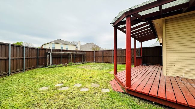 Fenced backyard with a wooden deck | Image 11
