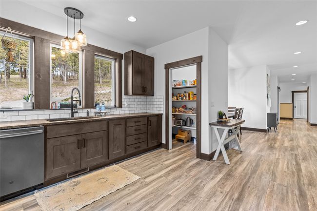 Kitchen featuring a wealth of natural light, dark brown cabinets, stainless steel dishwasher, and a sink | Image 5