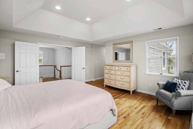 Double doors open to the upper-level landing, creating a grand entrance into the primary suite, which is complete with elegant finishes and ample space for a sitting area. | Image 23