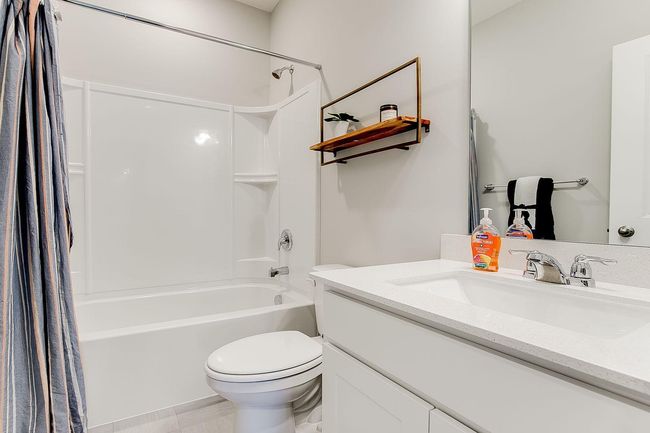 A peak inside the main level full bathroom! Photo of model home, color & options may vary. | Image 11