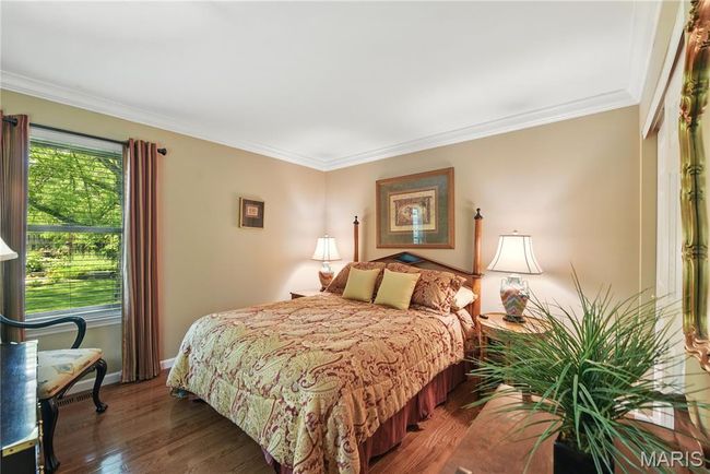 Bedroom with crown molding and wood finished floors | Image 13