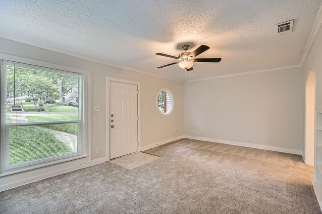 Entryway with ceiling fan, crown molding, visible vents, carpet, and a textured ceiling | Image 7