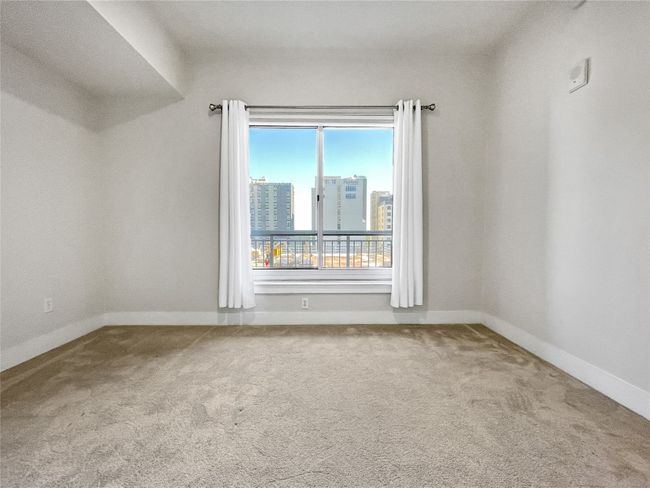 Spare room featuring carpet, baseboards, and a city view | Image 14