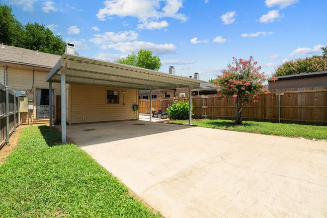 Rear view of house featuring an attached carport, a chimney, and driveway | Image 28