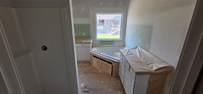 Bathroom featuring a bath, vanity, and a shower | Image 11