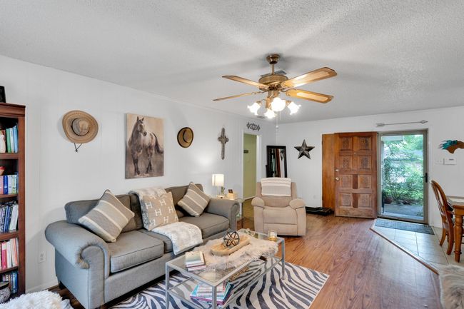 Living room featuring a textured ceiling, a ceiling fan, and light wood-type flooring | Image 6