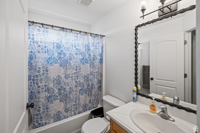 Bathroom featuring vanity and shower / bathtub combination with curtain | Image 18