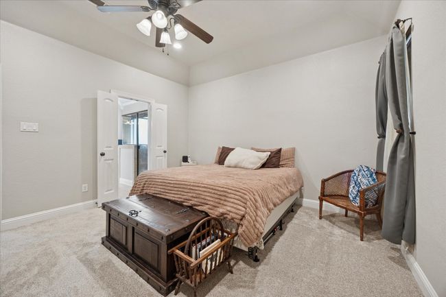 Bedroom featuring light carpet, baseboards, a ceiling fan, and lofted ceiling | Image 12