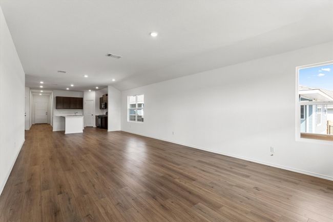 Unfurnished living room featuring recessed lighting and dark wood-style flooring | Image 12